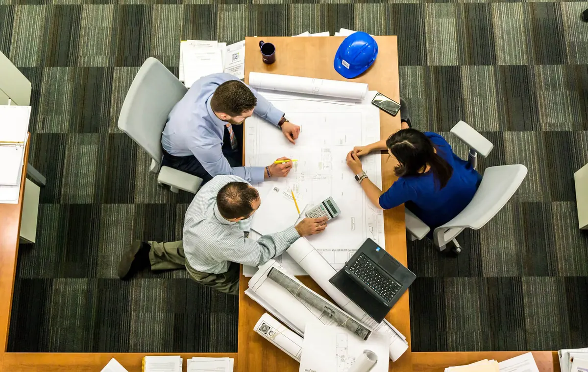 Team reviewing plans around a shared work table